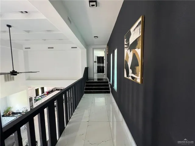 a view of a hallway with wooden floor and staircase