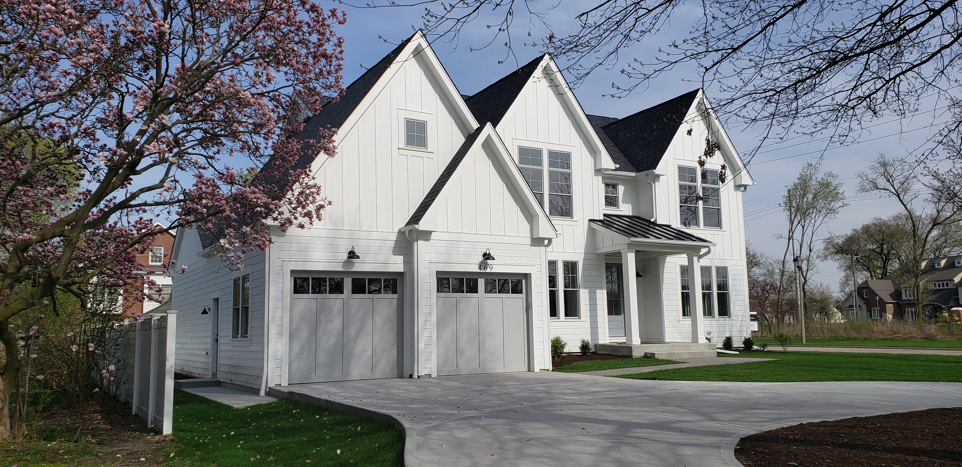 a view of a big house with a big yard and large trees