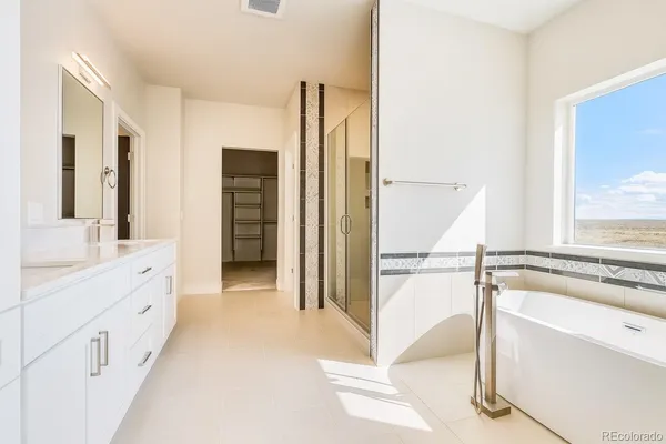 a bathroom with a tub sink and mirror