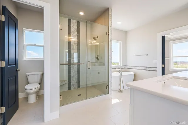 a bathroom with a tub sink toilet and shower