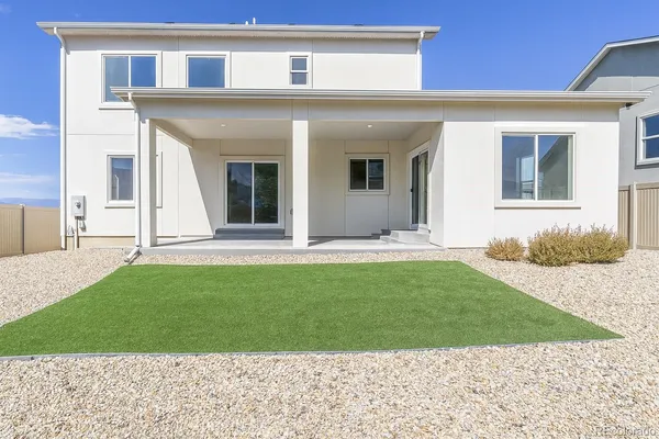 a view of a house with a yard and a car park