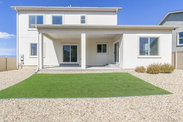 a view of a house with a yard and a car park