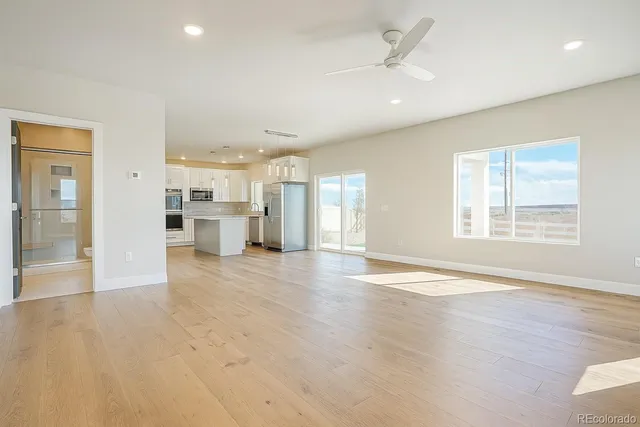 wooden floor in an empty room with a kitchen