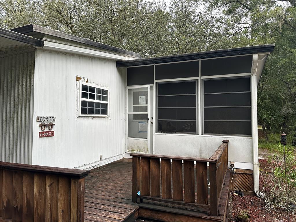 10625 Northeast 153 Street Fort McCoy, FL 32134 - Photo 4 of 7 a view of deck with wooden floor and a chair