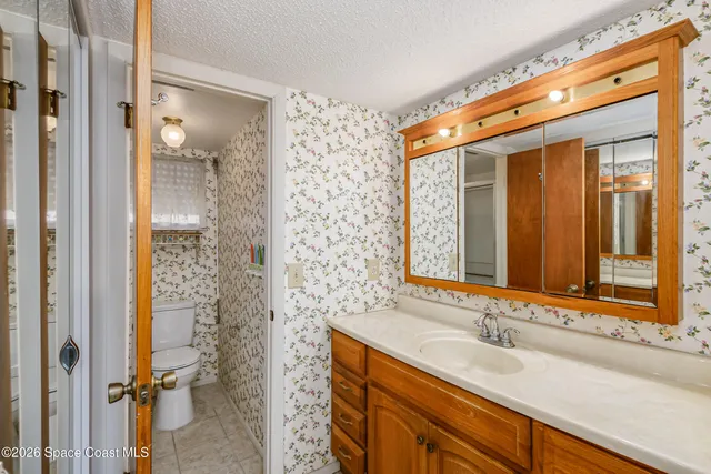 an empty room with a chandelier fan and windows