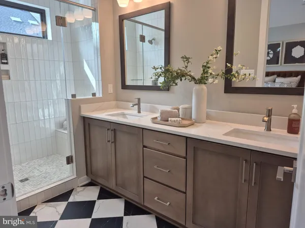 a bathroom with a double vanity sink mirror and shower