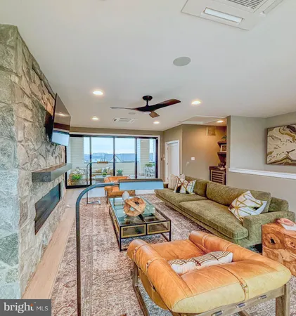a living room with furniture fireplace and large windows