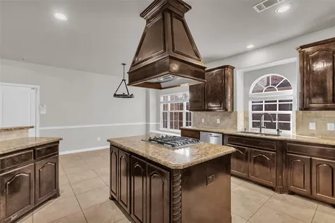 a kitchen with stainless steel appliances granite countertop a sink and a stove