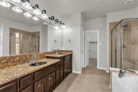 a kitchen with a granite countertop sink a large mirror and shower