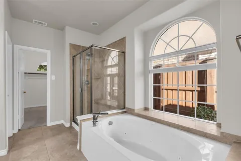 a spacious bathroom with a bathtub and a shower