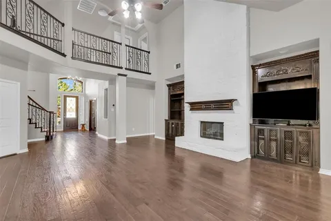 a view of a livingroom with wooden floor and a fireplace