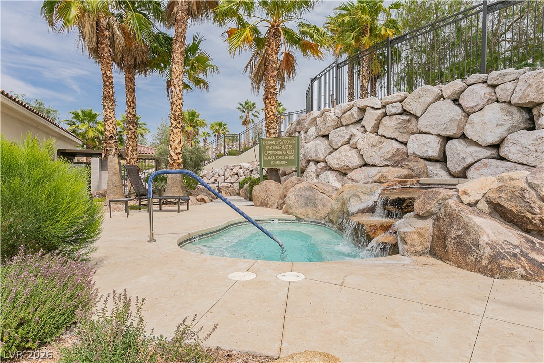 2555 Hampton Road, Unit 3308 Henderson, NV 89052 - Photo 62 of 65 A tranquil spa with a rock waterfall feature provides a serene outdoor escape.