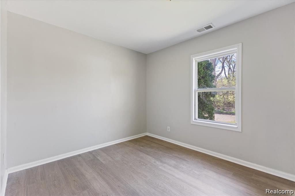 26076 Colgate Street Inkster, MI 48141 - Photo 17 of 24 Interior room featuring wood-finish flooring, light grey walls, white trim, and a white-framed window