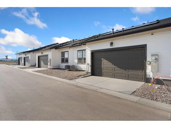 a backyard of a house with garage and barbeque oven