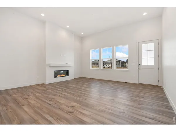 a view of an empty room with a window and fireplace