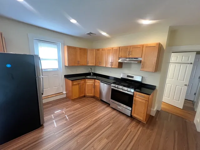 a kitchen with stainless steel appliances granite countertop a stove a sink and a refrigerator