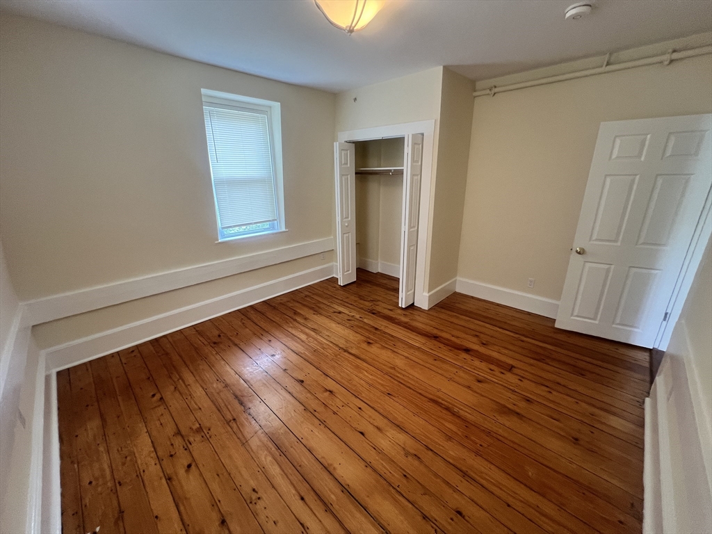 10 Centennial Place, Unit 2 Framingham, MA 01701 - Photo 10 of 12 a view of an empty room with wooden floor and a window