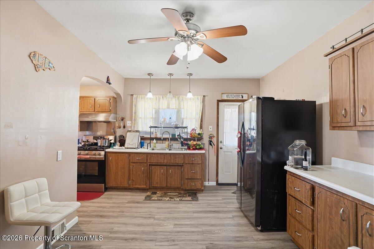 227 Reese Street Scranton, PA 18508 - Photo 16 of 56 a kitchen with stainless steel appliances granite countertop a refrigerator a stove a sink and a dining table with wooden floor