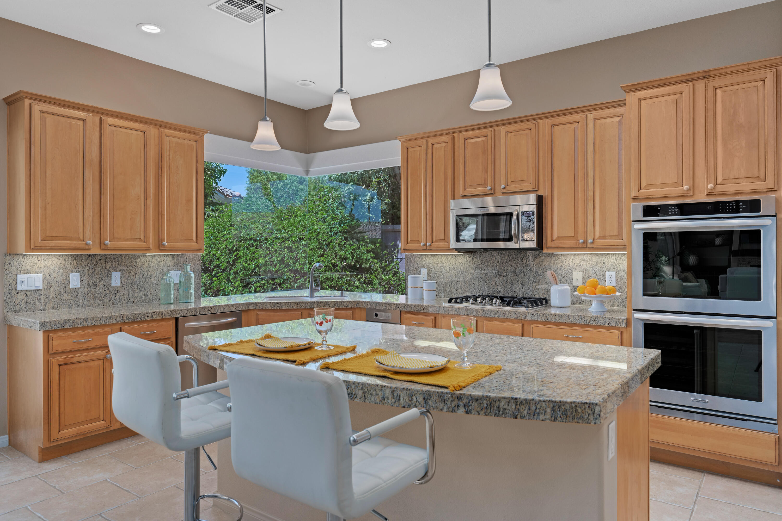 35691 Talus Lane Palm Desert, CA 92211 - Photo 21 of 39 a kitchen with stainless steel appliances granite countertop a sink a microwave a stove and a refrigerator