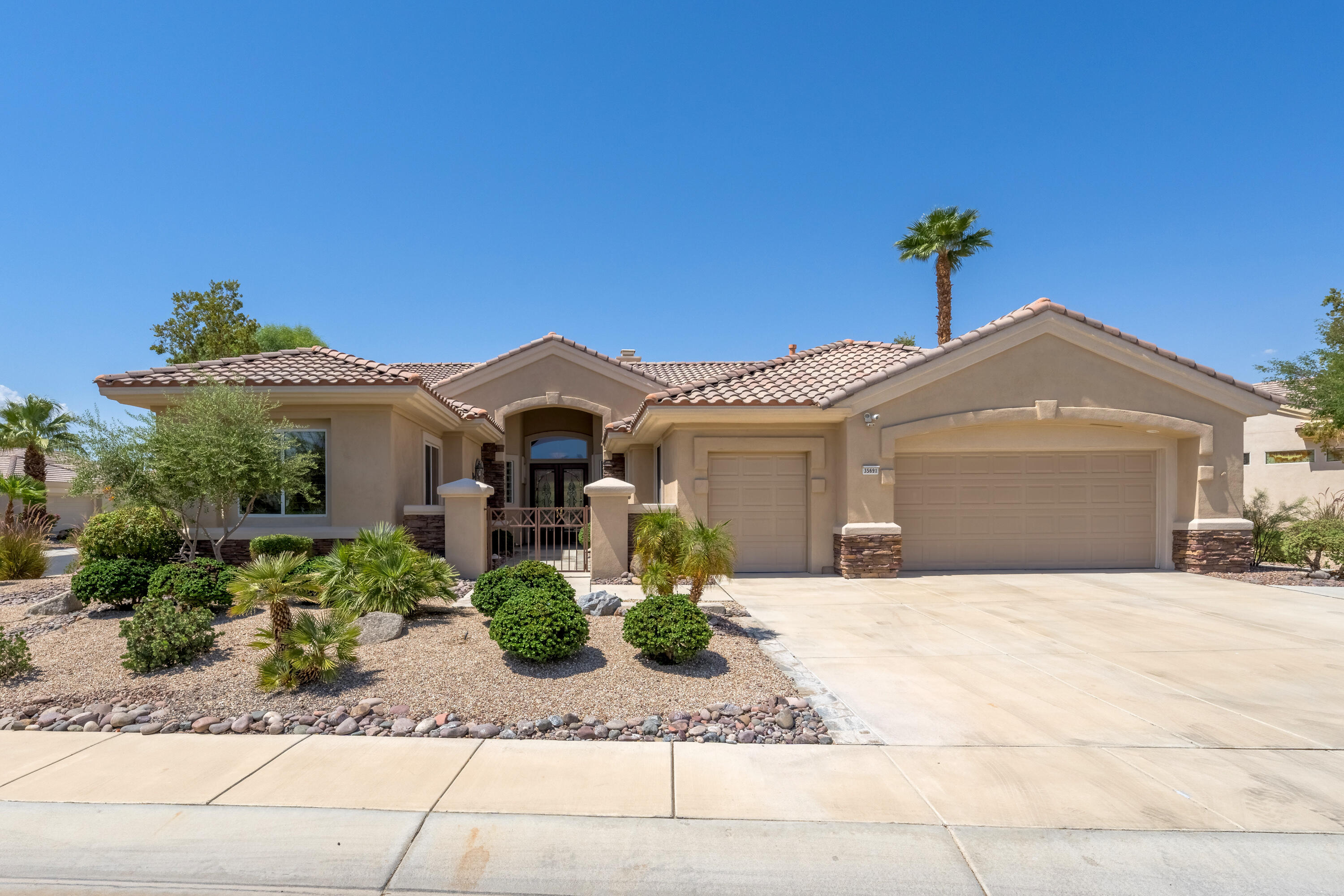 35691 Talus Lane Palm Desert, CA 92211 - Photo 10 of 39 a front view of a house with a yard and potted plants
