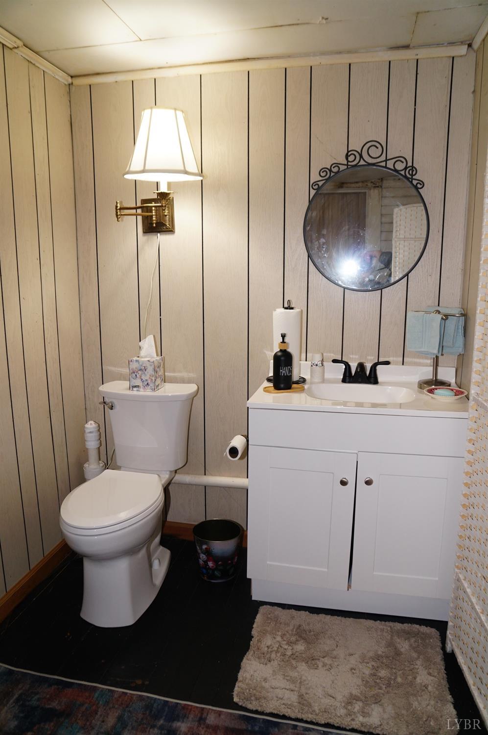 10188 Stage Coach Road Gretna, VA 24557 - Photo 27 of 56 a bathroom with a granite countertop toilet sink and mirror