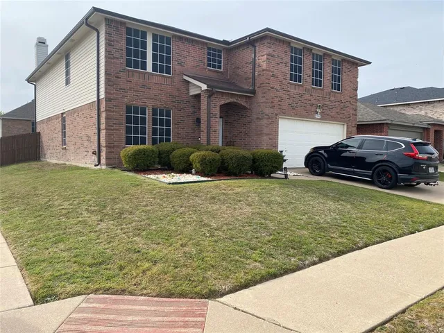a front view of a house with a garden and yard