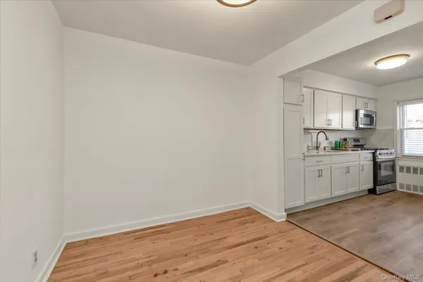 a view of a kitchen with white cabinets and wooden floor