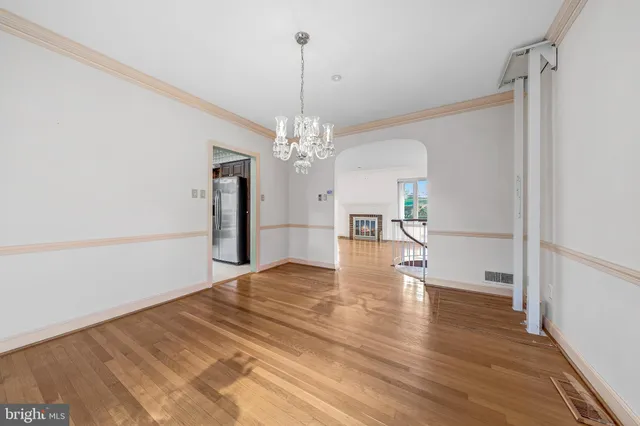 a view of a livingroom with wooden floor a ceiling fan and window