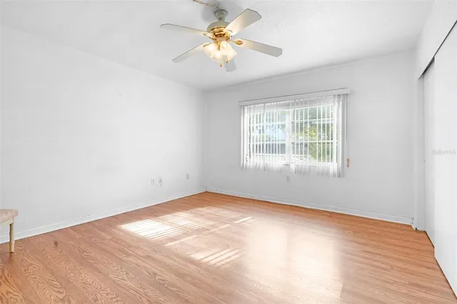 an empty room with a window and a fan