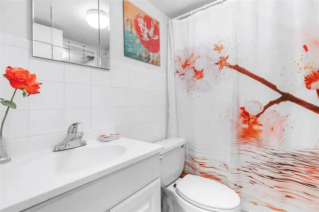 a bathroom with a sink vanity mirror and toilet