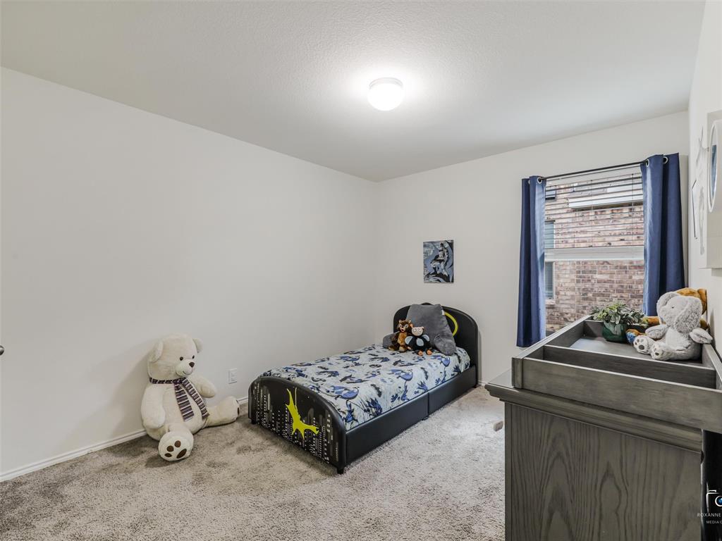 4517 Ashmark Road Aubrey, TX 76227 - Photo 9 of 26 a bedroom with a bed and a window