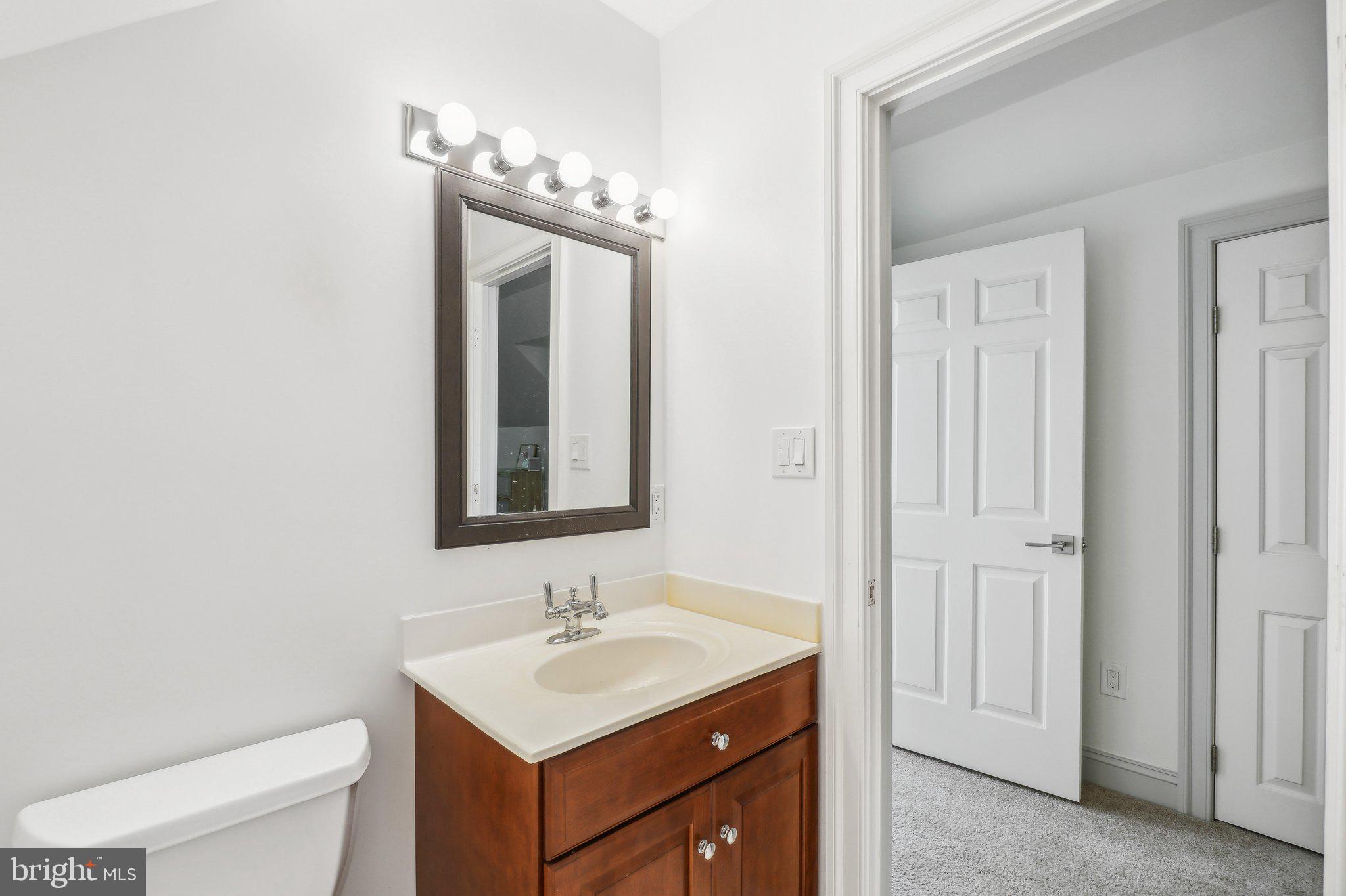 8683 Reservoir Road Fulton, MD 20759 - Photo 49 of 60 a bathroom with a toilet a sink a mirror and vanity