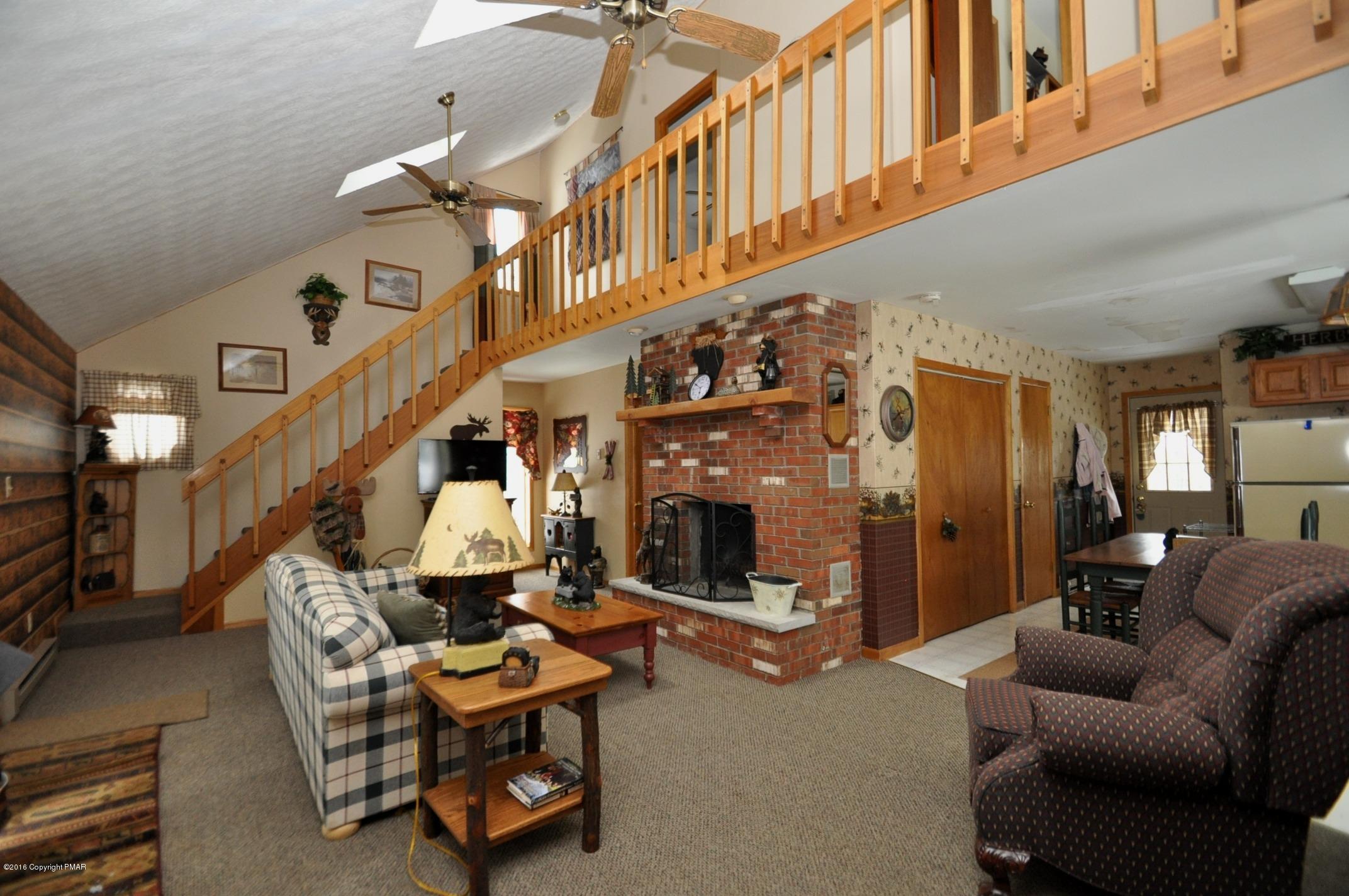 2 Brier Crest Road Blakeslee, PA 18610 - Photo 4 of 15 a living room with furniture a fireplace and a large mirror with potted plants