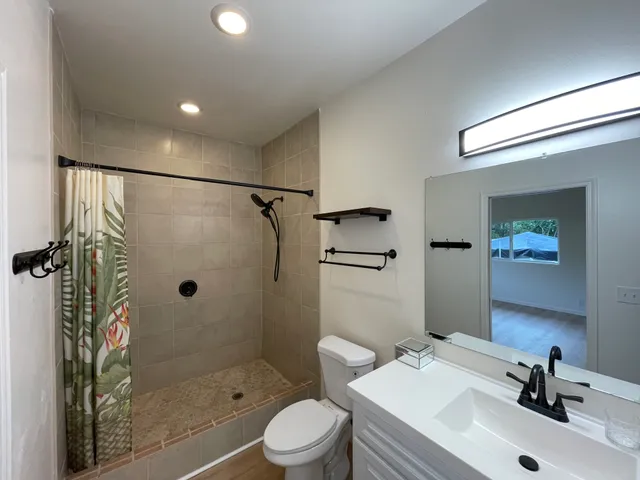 a bathroom with a bathtub sink mirror toilet and shower