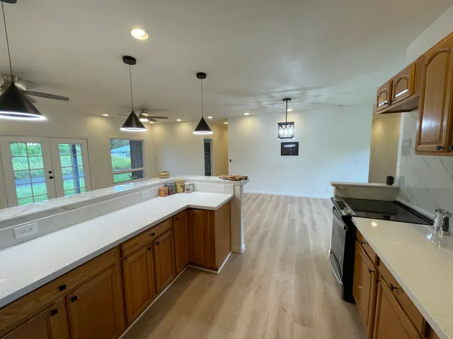 a kitchen with kitchen island a sink stove and wooden floor