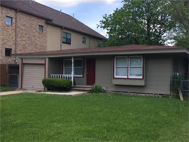 a view of a house with a yard and a large tree