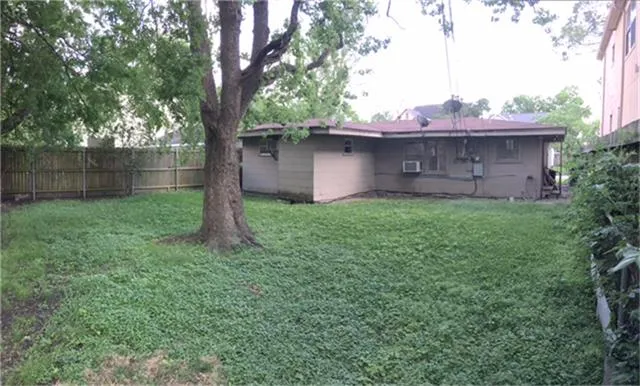 a view of a yard with a tree and a fence