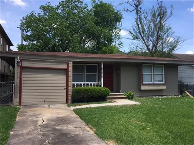 a view of a house with a yard and a large tree