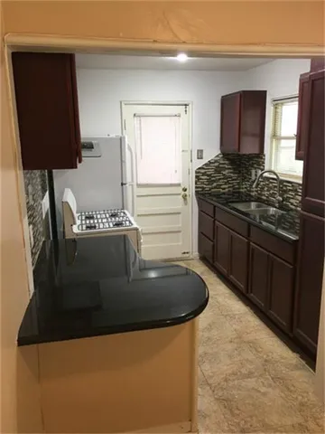 a kitchen with granite countertop a sink and a stove