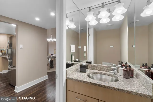 a bathroom with a granite countertop sink a mirror and a shower