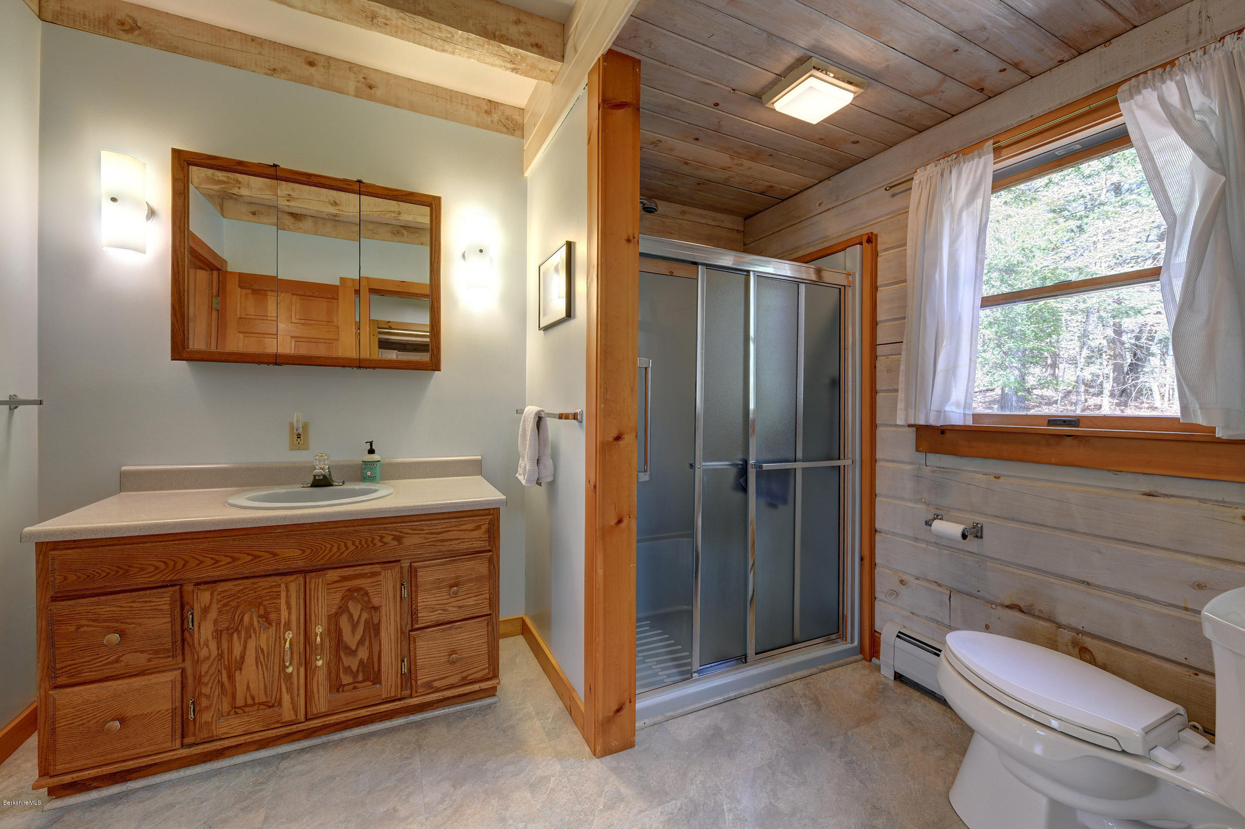 251 Captain Whitney Road Becket, MA 01223 - Photo 19 of 37 a bathroom with a toilet a sink and mirror