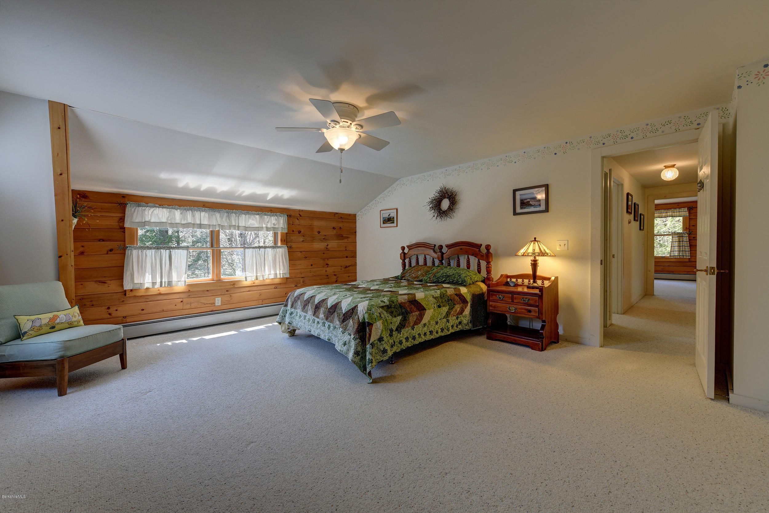 251 Captain Whitney Road Becket, MA 01223 - Photo 22 of 37 a spacious bedroom with a bed and a chandelier