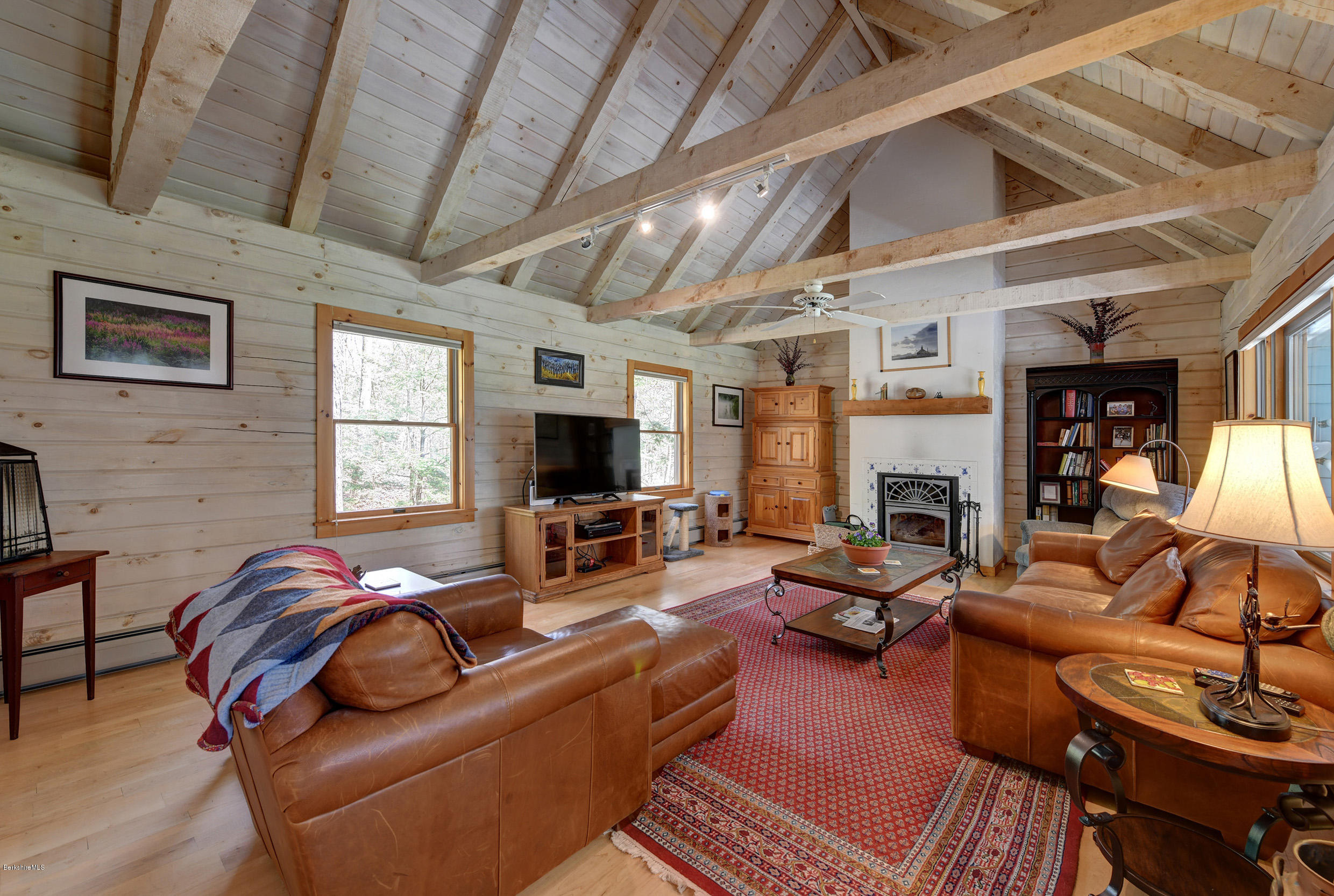 251 Captain Whitney Road Becket, MA 01223 - Photo 6 of 37 a living room with furniture a fireplace and a flat screen tv