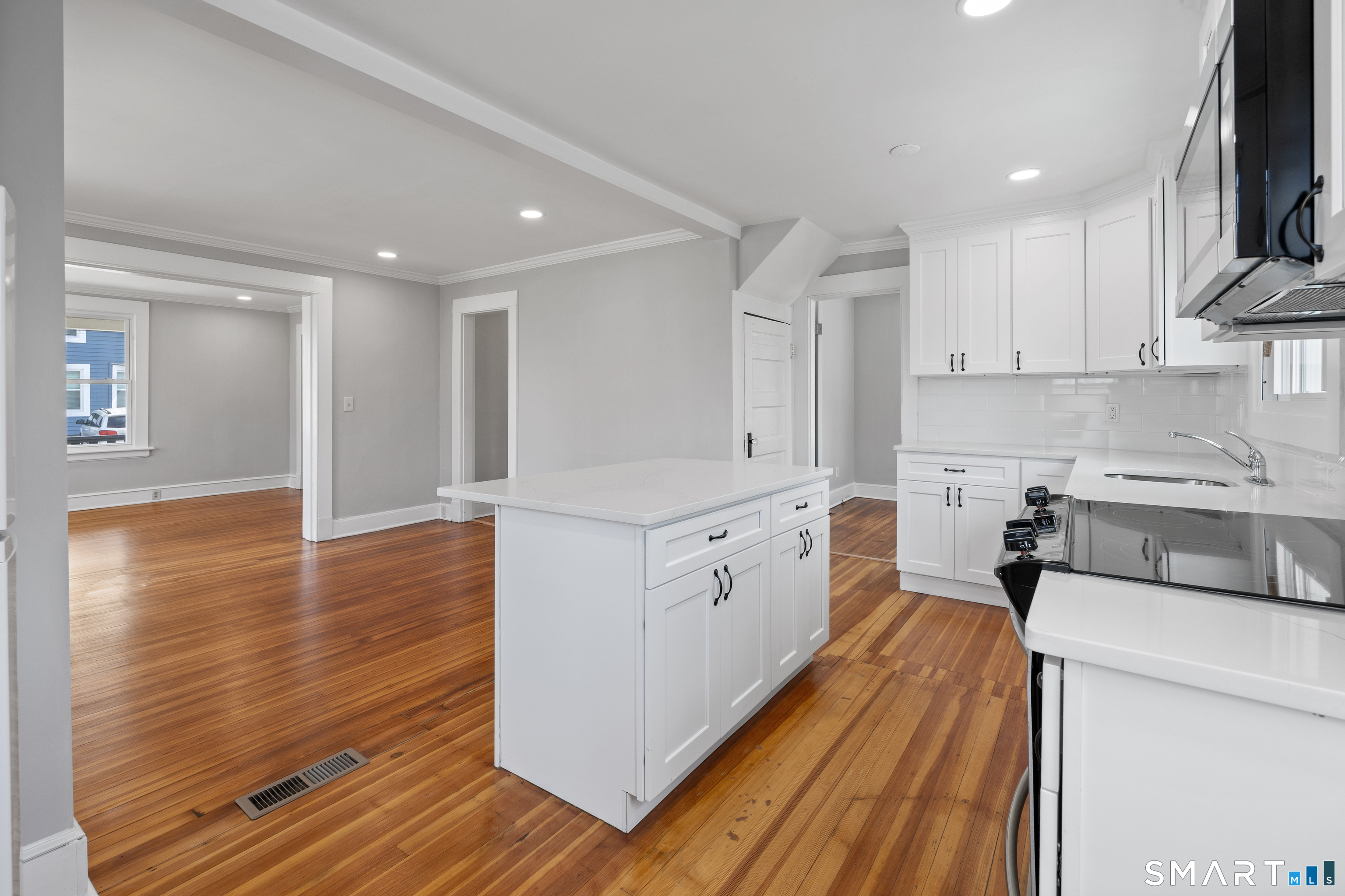 22 Merrimac Street Watertown, CT 06779 - Photo 6 of 17 a kitchen with wooden floors and white cabinets