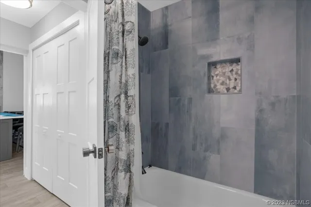 a dining hall with stainless steel appliances kitchen island granite countertop a dining table chairs and a refrigerator