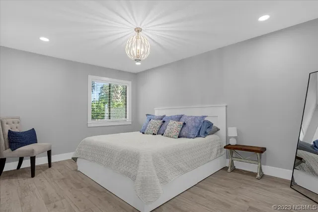 a bedroom with a large bed and a chandelier