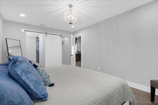 a bedroom with a large bed and a chandelier