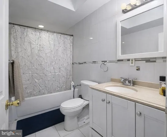 a bathroom with a toilet a sink a mirror a bathtub and vanity