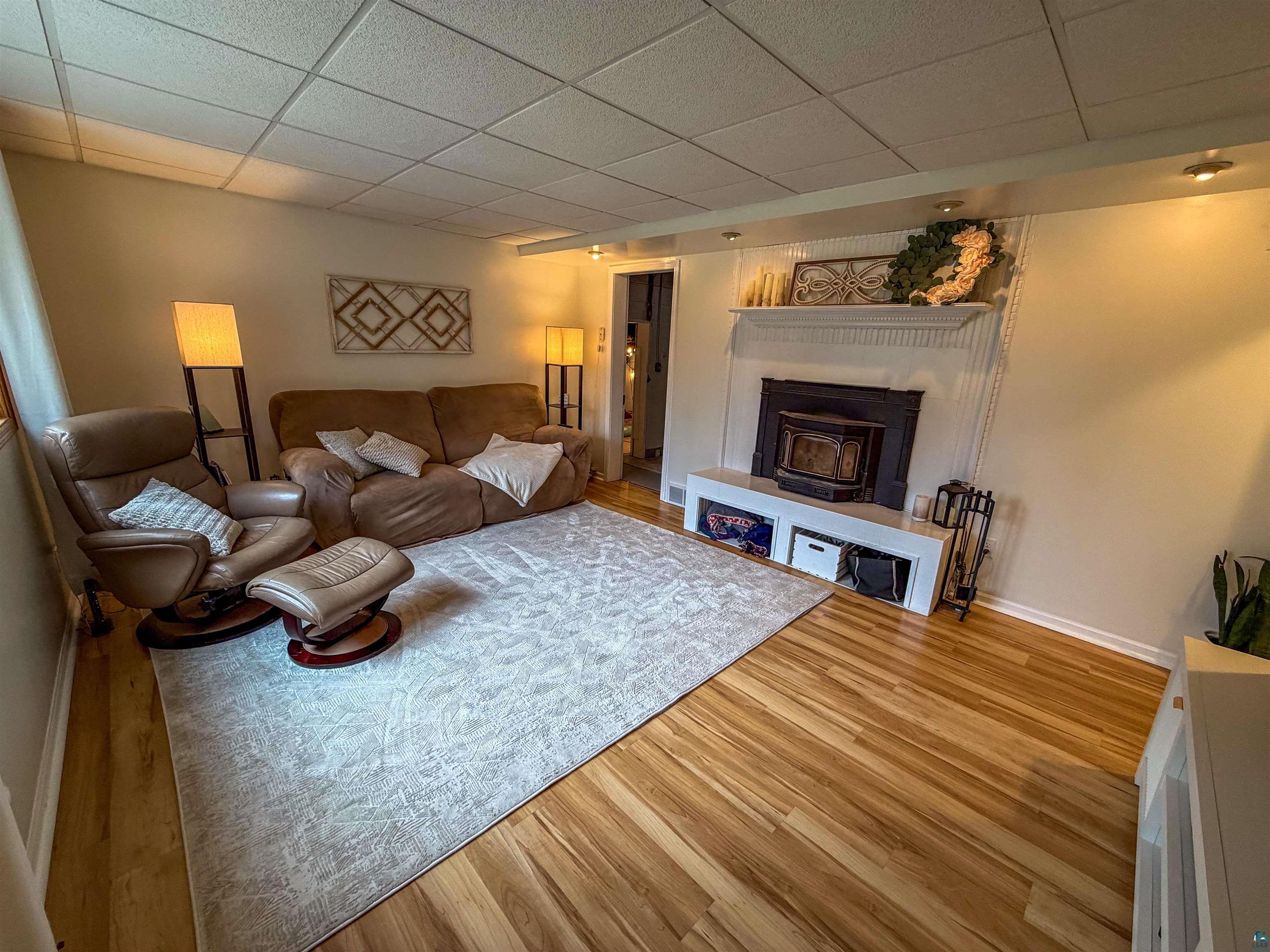 3704 Greysolon Road Duluth, MN 55804 - Photo 22 of 51 Living area featuring wood-finish flooring, a white mantel, and a built-in fireplace insert
