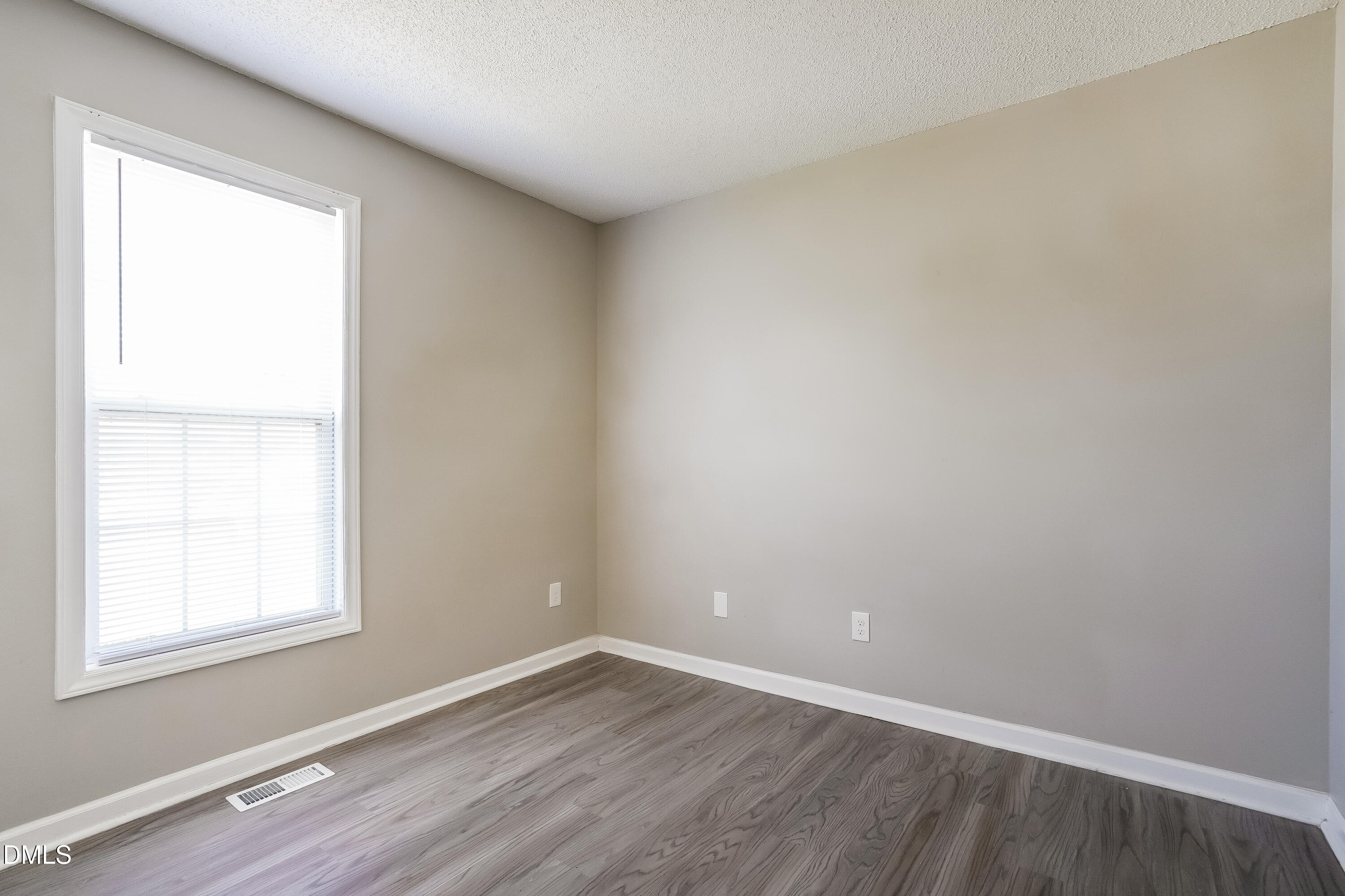 1410 Mandolin Place Zebulon, NC 27597 - Photo 13 of 16 an empty room with wooden floor and windows